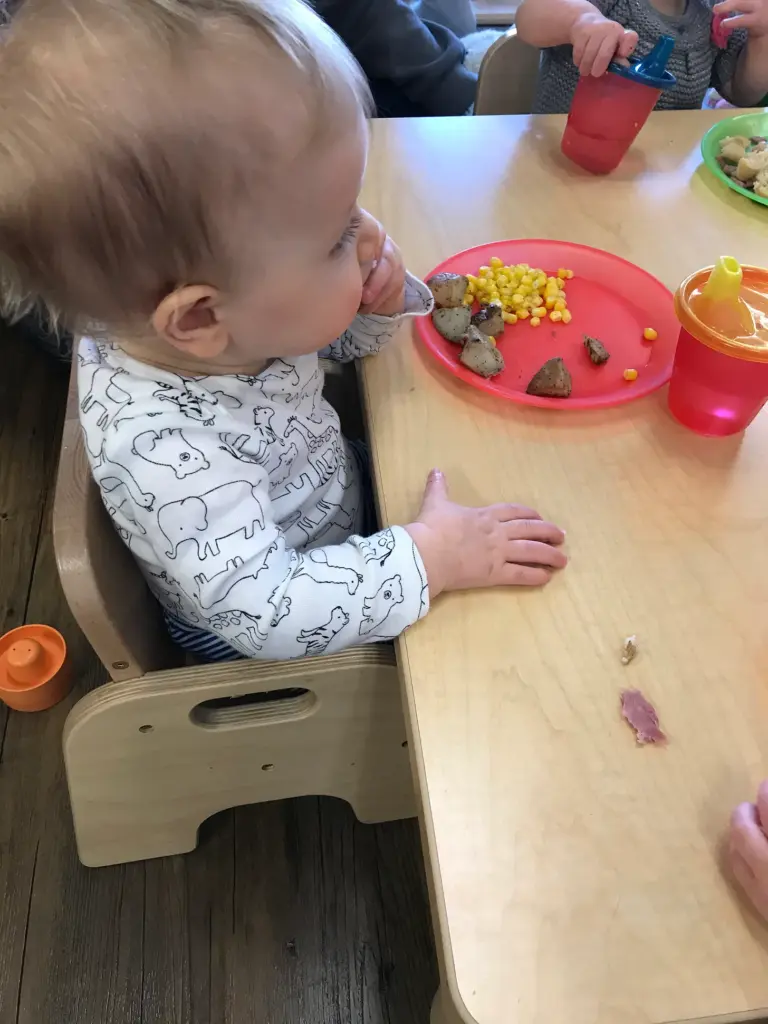 Child at daycare eating a snack. 