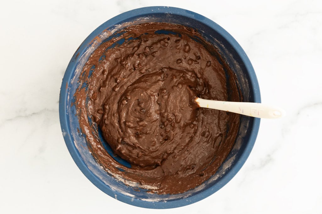 Batter for chocolate banana muffins in blue bowl.