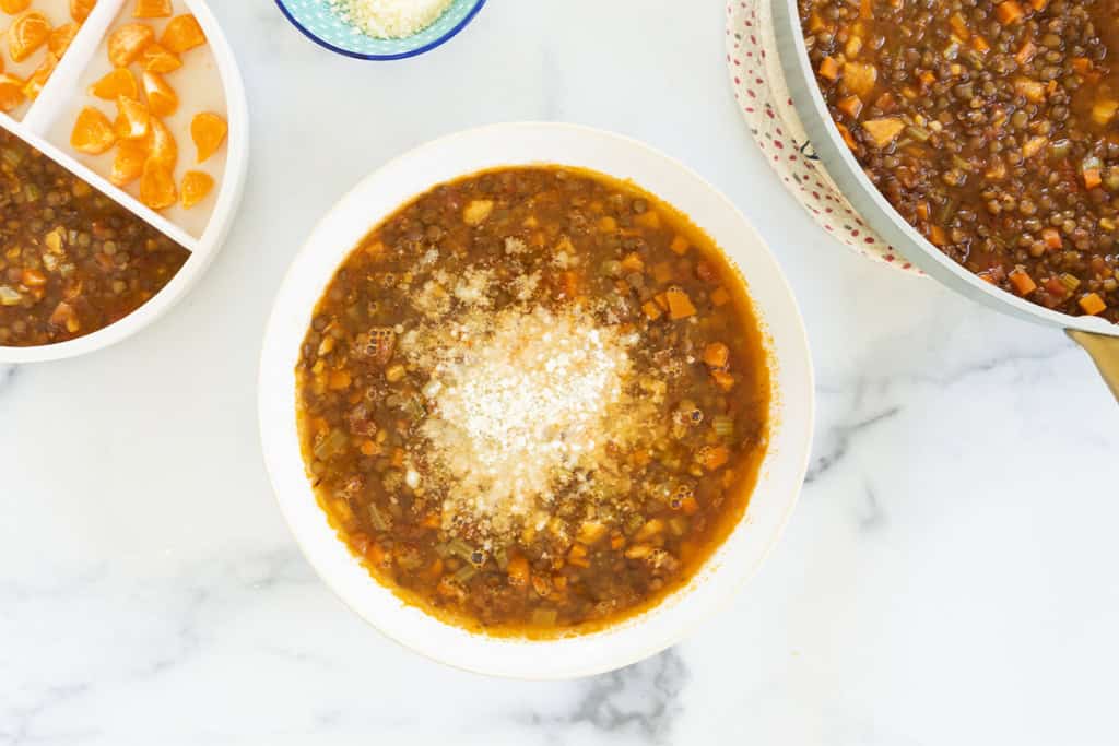 Lentil soup in bowl with cheese on top.