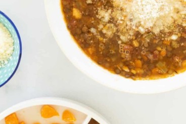 Lentil soup in bowl with cheese on top.