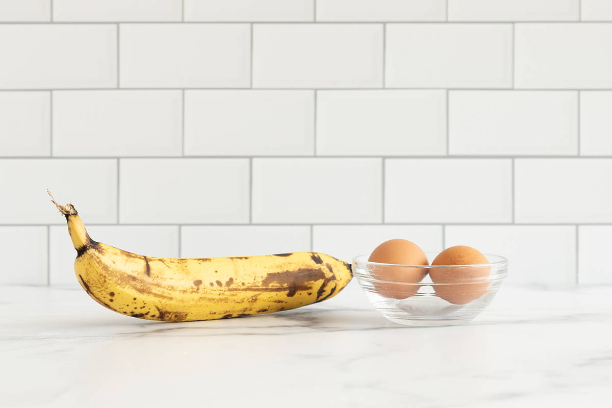 Ingredients for banana pancakes on countertop.