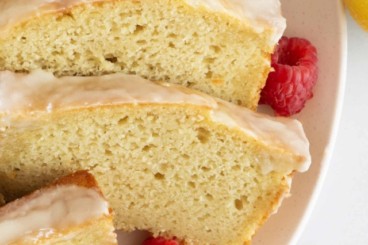 Slices of lemon yogurt cake on white plate with berries.