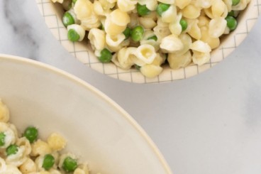 Pasta with peas in white bowl.