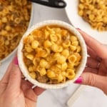 Hands holding bowl of cheeseburger pasta.