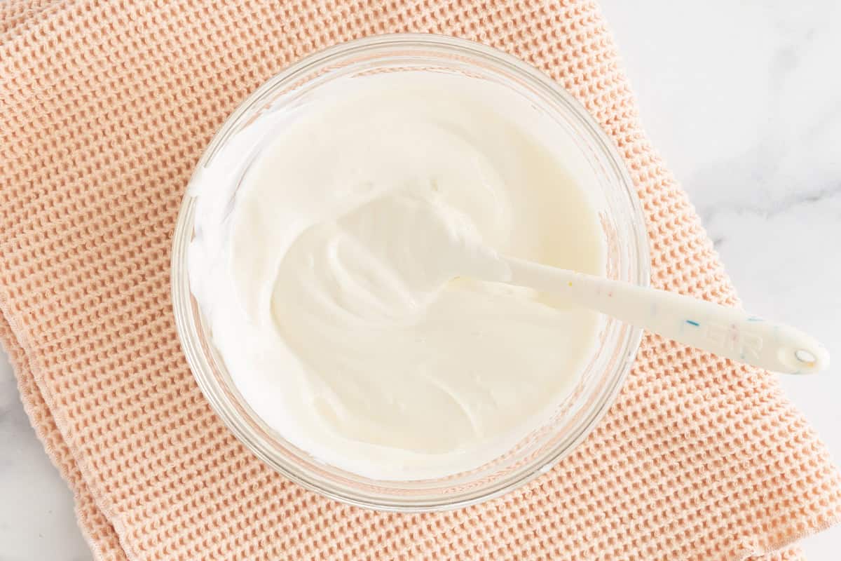 Yogurt in glass bowl with spoon for frozen yogurt bites.