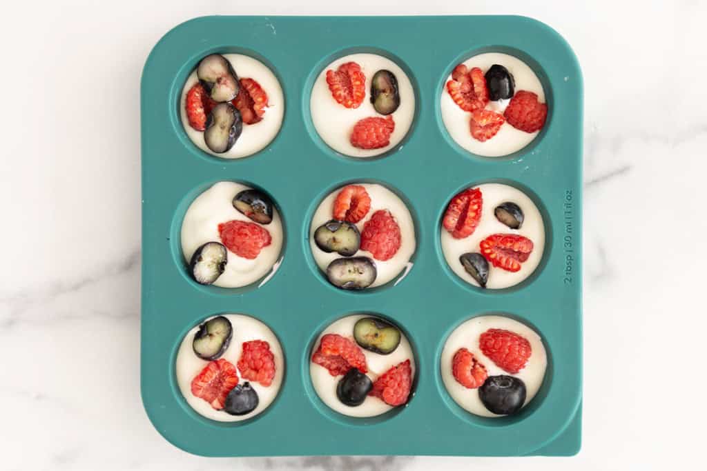 Frozen yogurt bites in blue silicon mold before freezing.