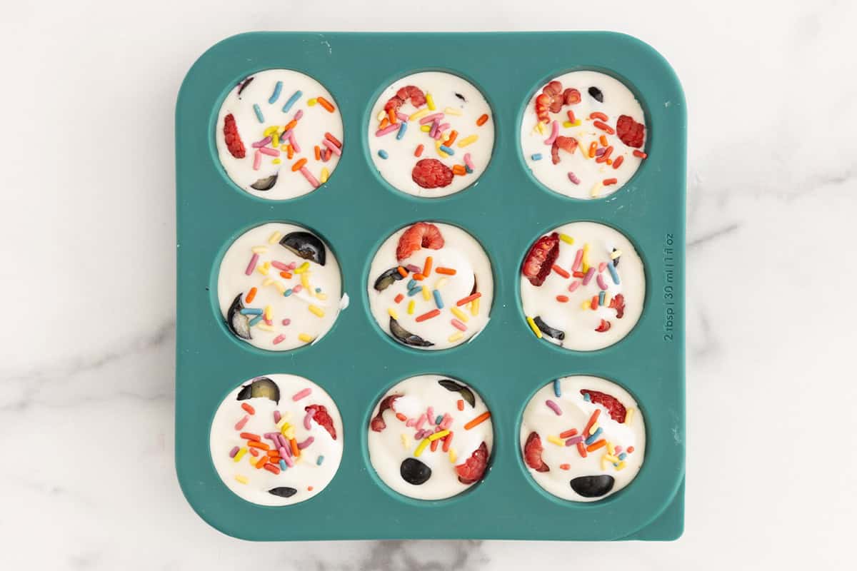 Frozen yogurt bites in blue silicon mold after freezing.