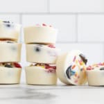 Frozen yogurt bites stacked together on countertop.