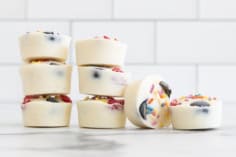 Frozen yogurt bites stacked together on countertop.