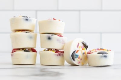 Frozen yogurt bites stacked together on countertop.