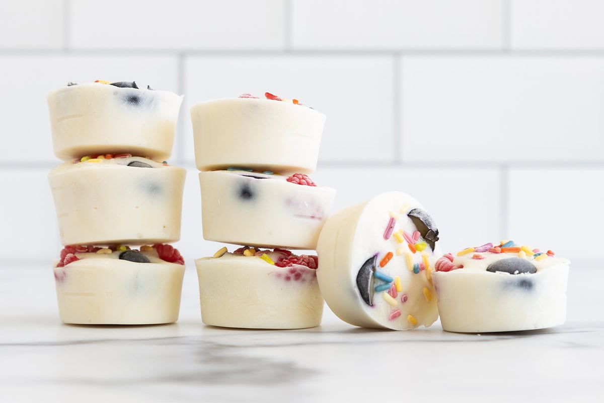 Frozen yogurt bites stacked together on countertop. 