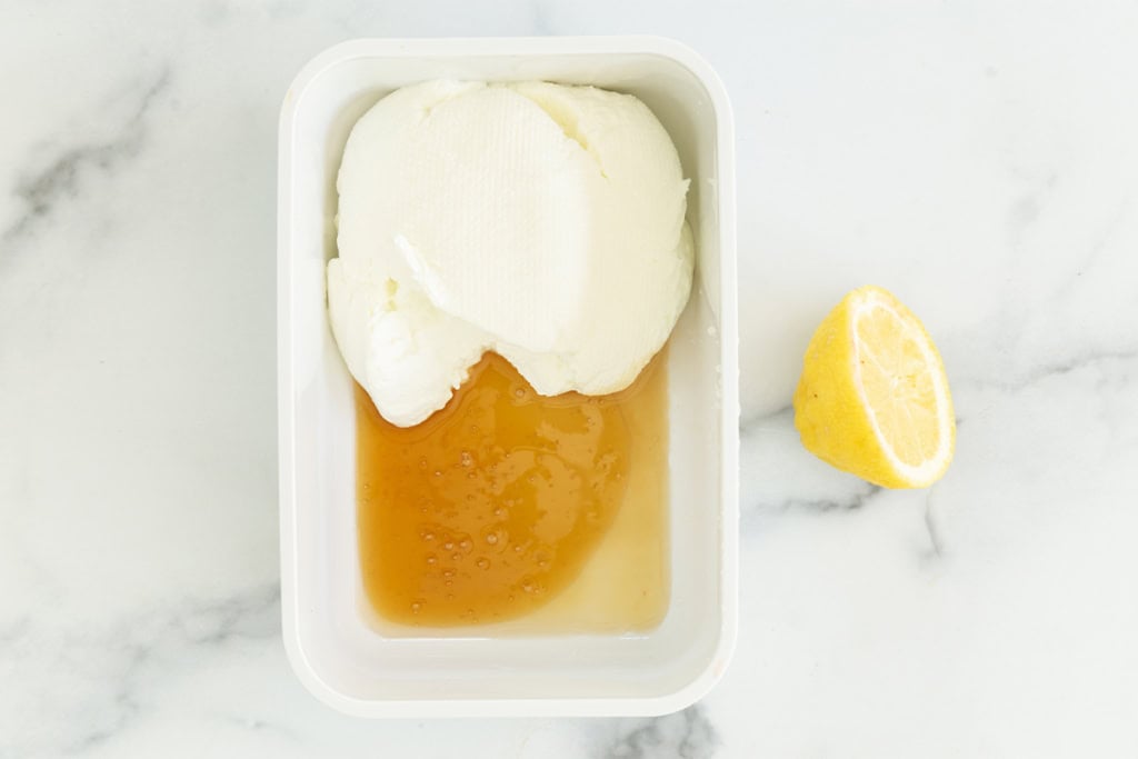 Greek yogurt with honey in white container for greek frozen yogurt.