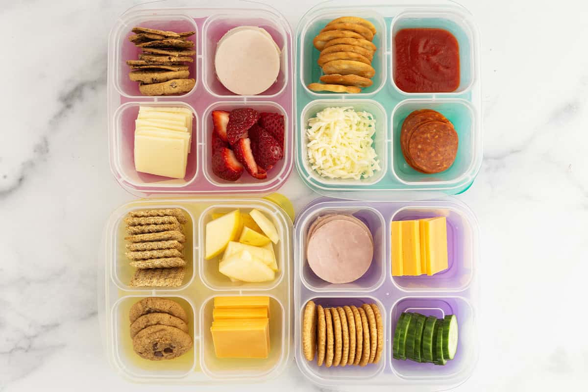 four containers with homemade lunchables in them.