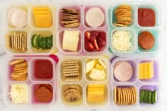 Six containers with homemade lunchables in them.