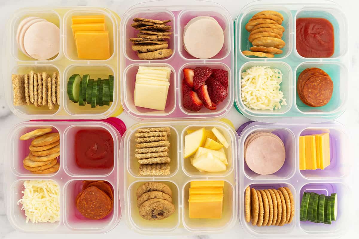 Six containers with homemade lunchables in them. 