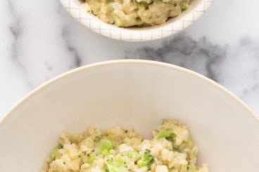 Cheesy broccoli rice in two white bowls.