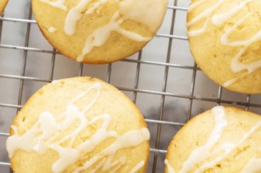 Lemon muffins on cooling rack with lemon drizzle.