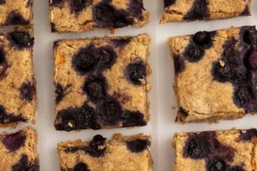 Oatmeal bars cut into squares on parchment paper.