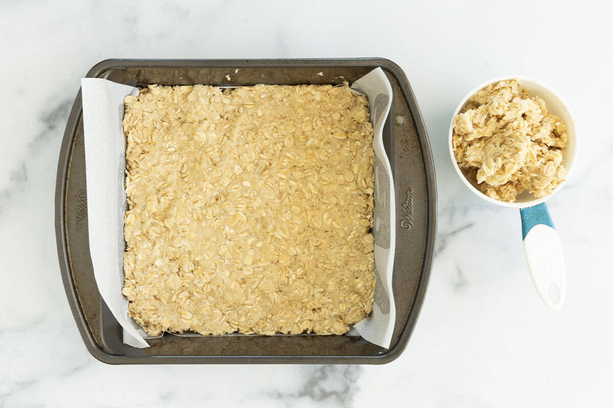 Crust pressed into baking pan for strawberry oatmeal bars.