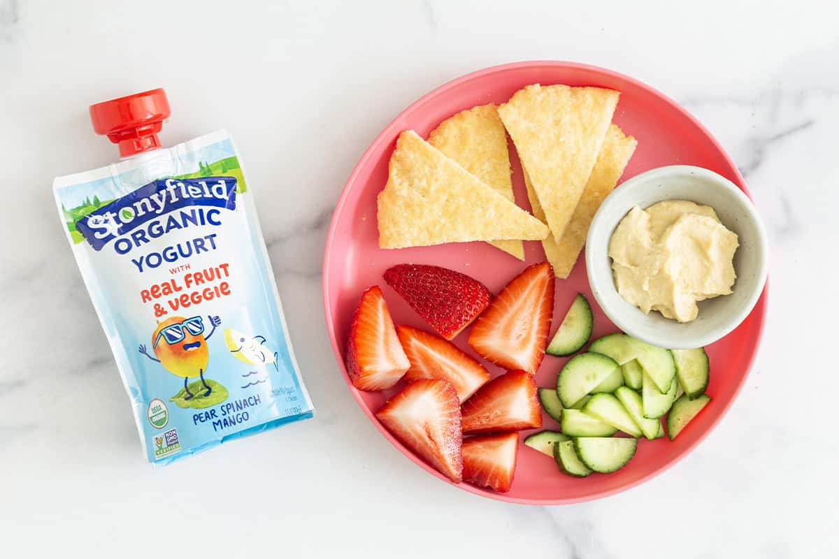 Yogurt flatbread on kids plate with yogurt pouch on side.