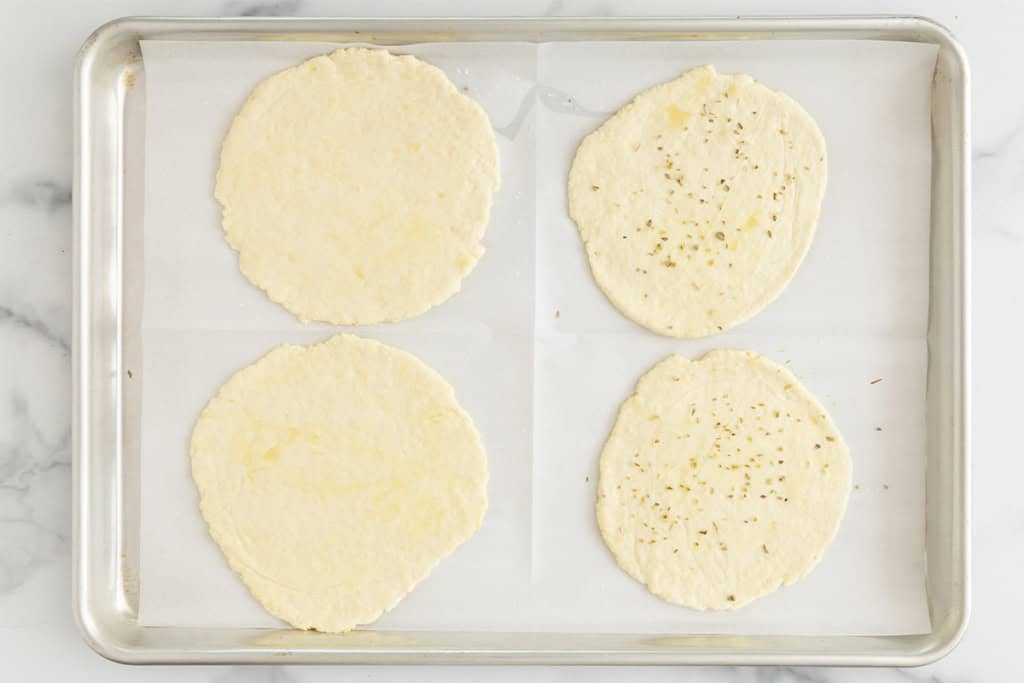 Yogurt flatbread dough rolled out on baking sheet.