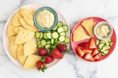 Yogurt flatbread on two plates with dip and sides.