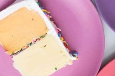 Ice cream cake slice on purple plate.