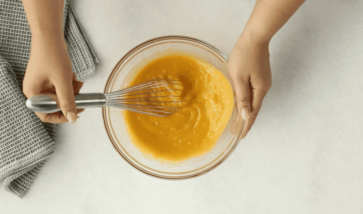sweet potato cake wet ingredients in glass bowl with whisk. 
