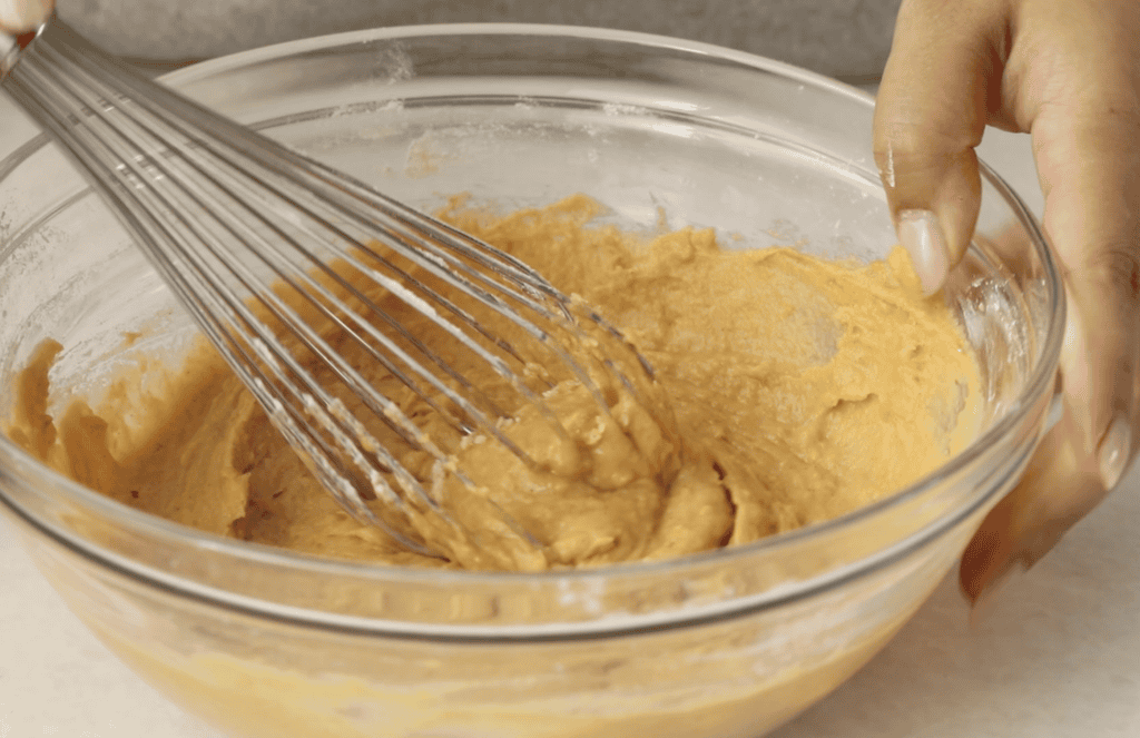 sweet potato cake batter in glass bowl with whisk.
