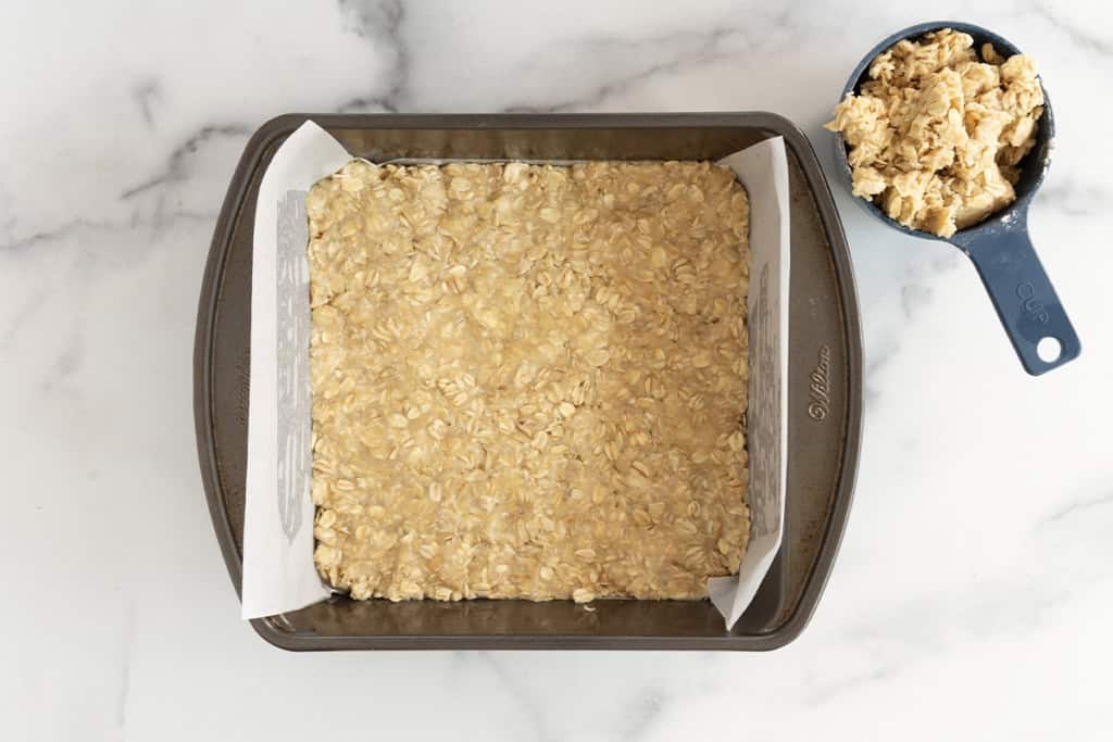 Crust for blueberry oatmeal bars pressed into baking pan.