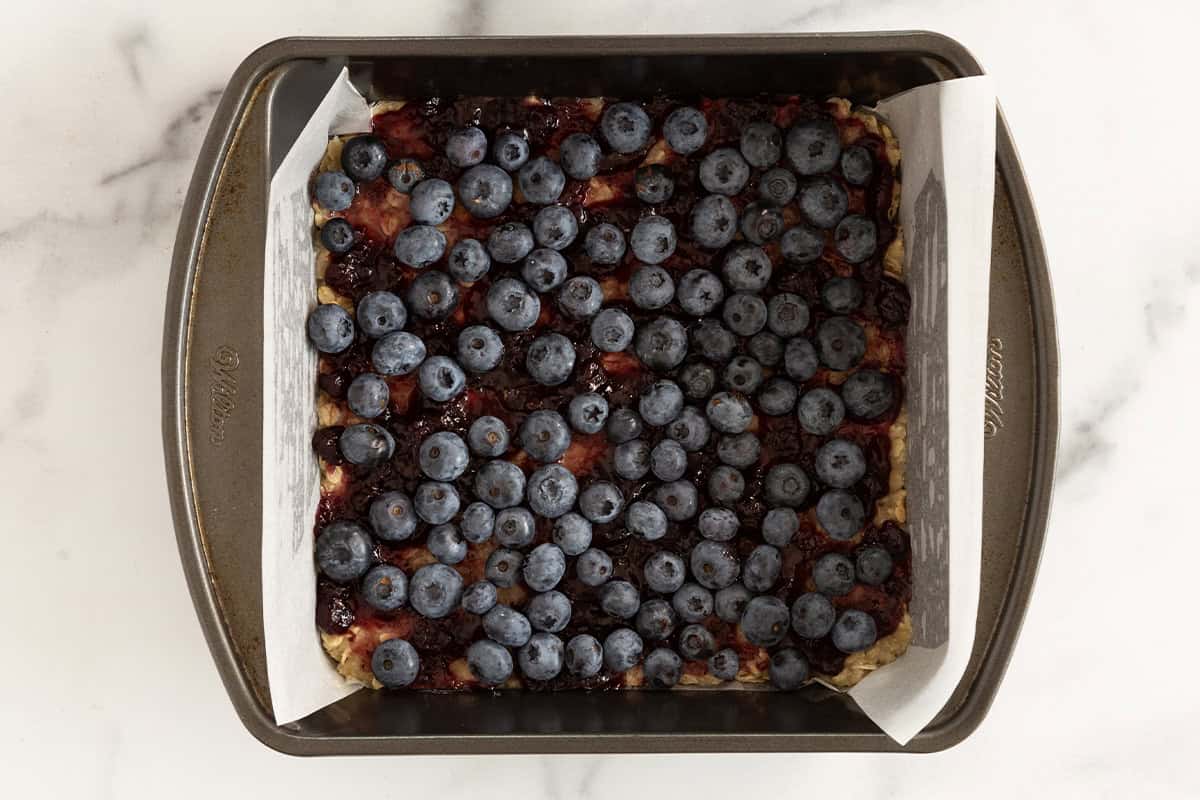 Blueberries in baking pan for blueberry oatmeal bars.