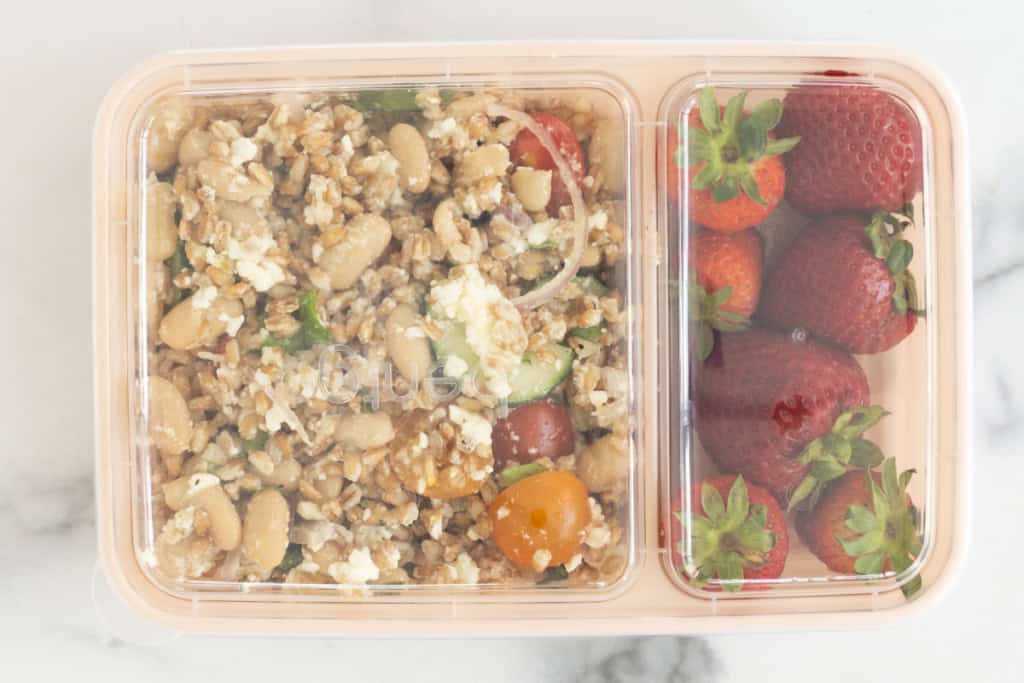 Farro salad with strawberries in lunch container with lid.