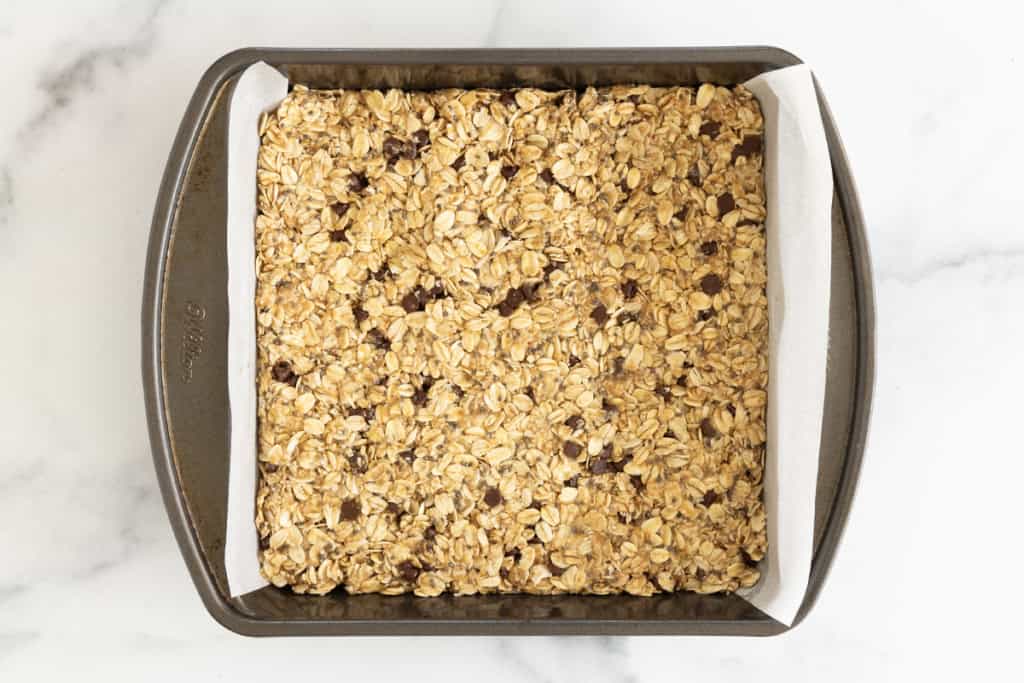 Healthy granola bars in baking pan before baking.