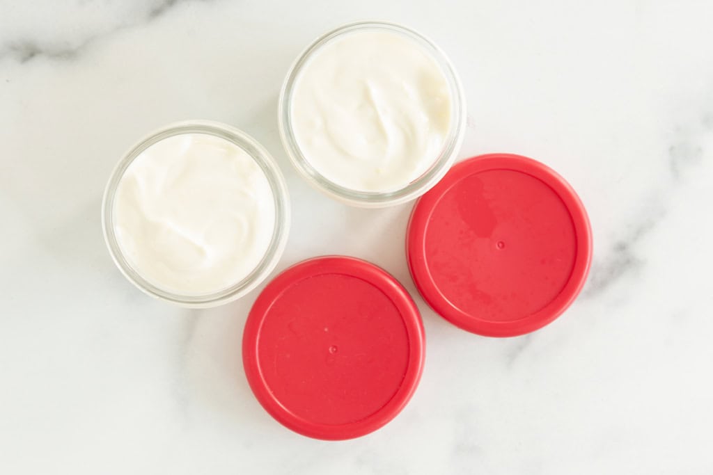 Lemon yogurt in glass storage containers with lids on side.