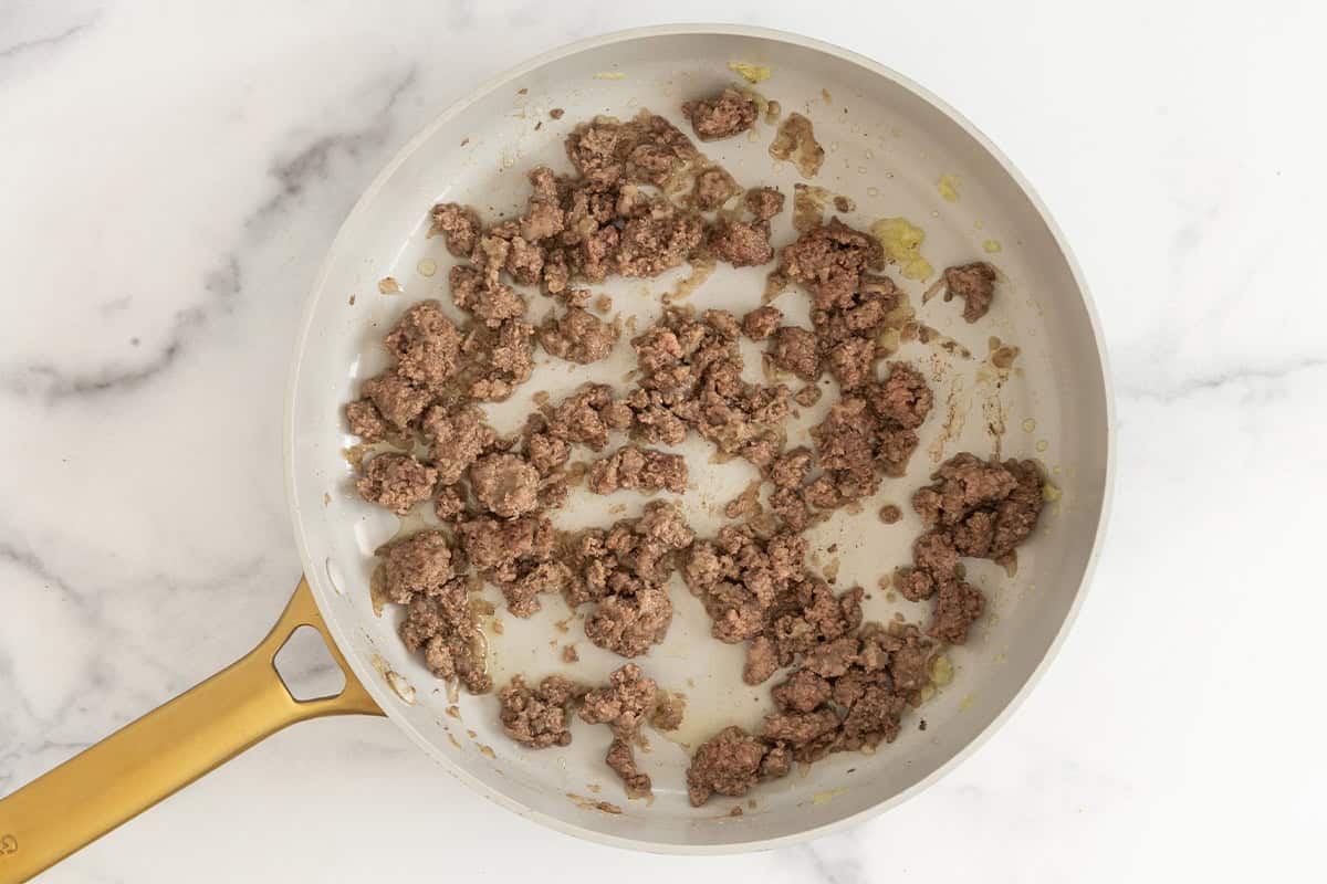 Ground beef cooking in pan for taco pasta.