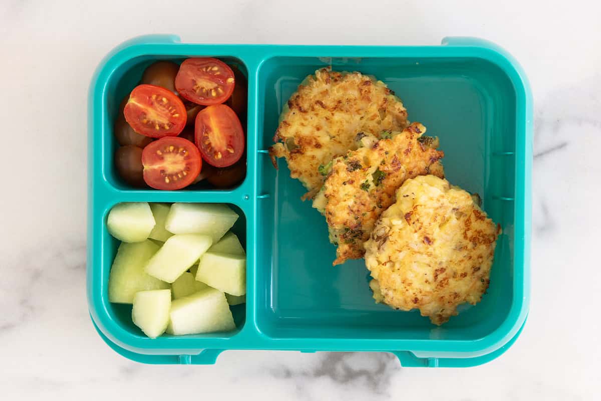 Lunchbox with fritters and sides.