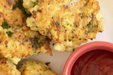 Chicken fritters on plate with ketchup.