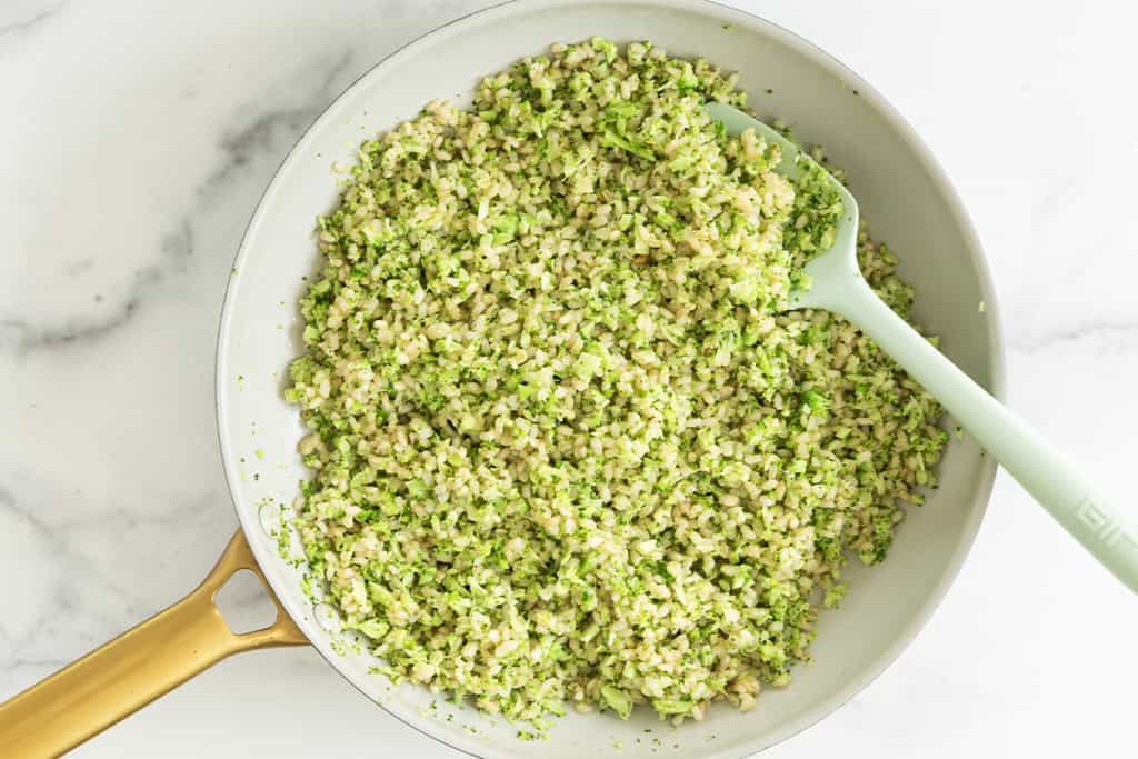 Broccoli rice in pan with spatula.