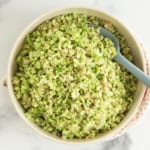 Broccoli rice in bowl with spoon.