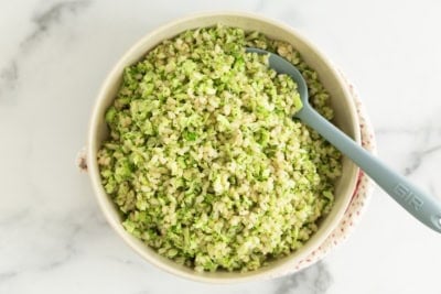 Broccoli rice in bowl with spoon.