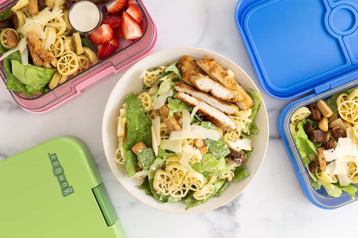 chicken caesar pasta salad in bowl and lunch boxes. 