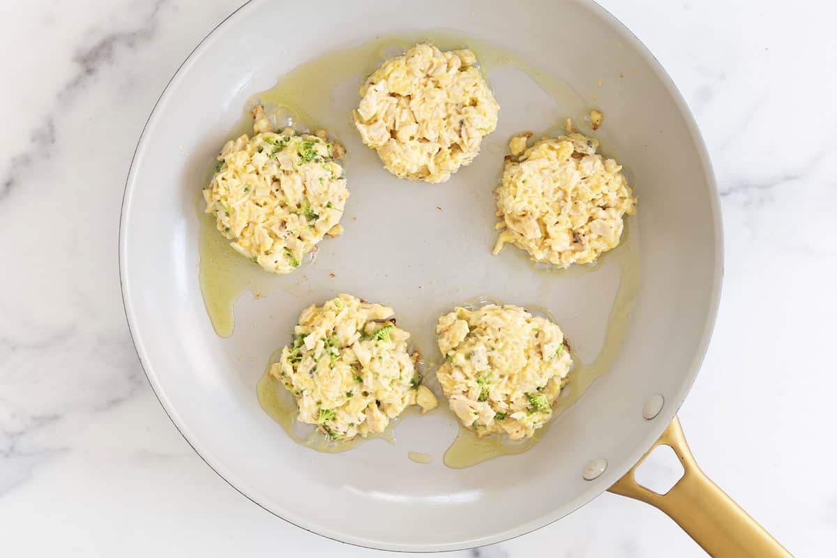 Chicken fritters in pan before flipping.