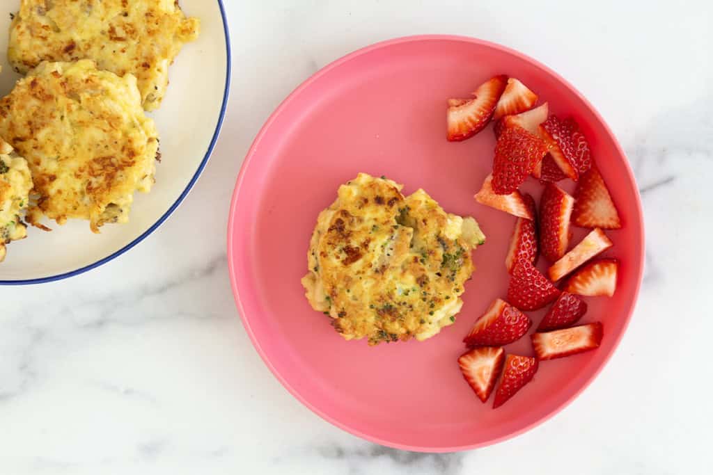 Chicken fritters on two plates with strawberries.