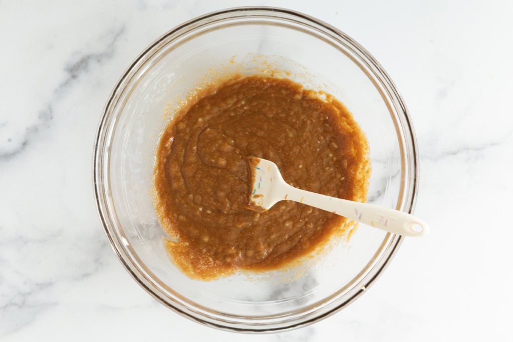 Wet ingredients in glass bowl for peanut butter granola bars.