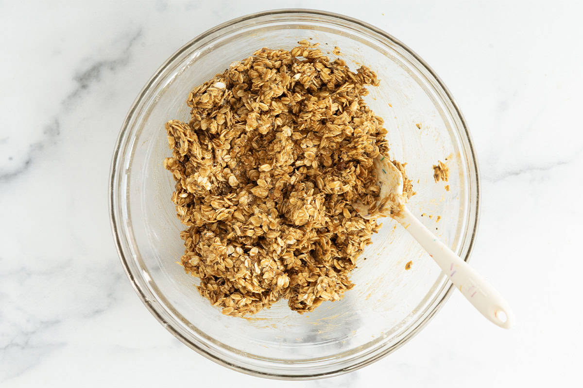 Mixture for peanut butter granola bars in glass bowl.