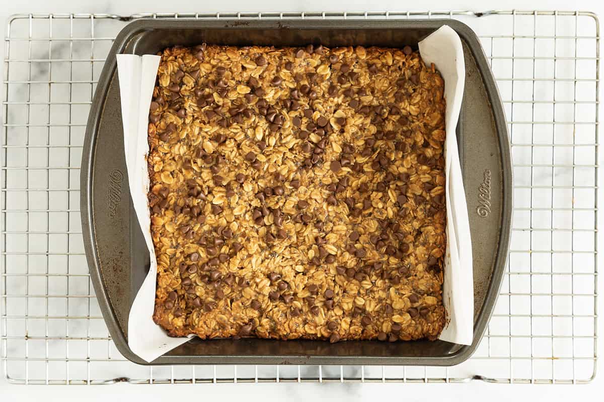 Peanut butter granola bars with chocolate chips pressed into baking pan.