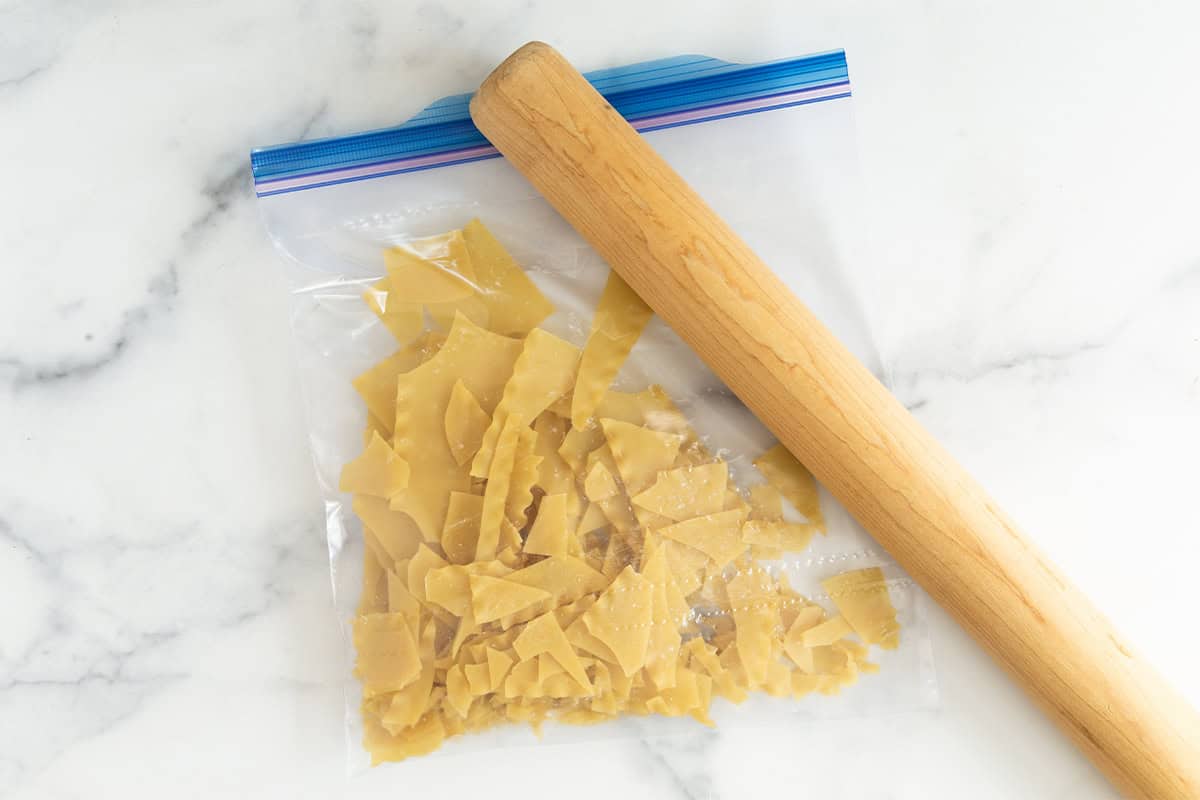 Lasagna noodles being broken up in plastic bag for skillet lasagna.