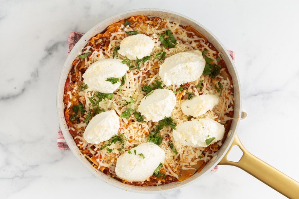 Skillet lasagna in pan with cheese on top.