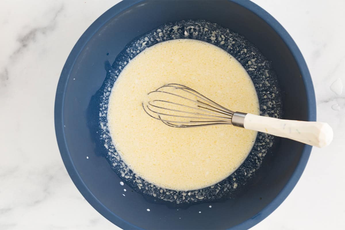 Wet ingredients for baked donuts in blue bowl.