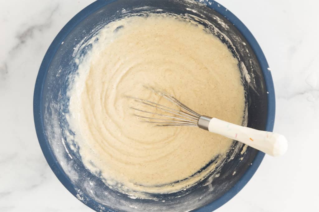 Batter for baked donuts in blue bowl.